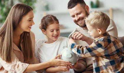 financial planning happy family mother father and children with piggy Bank at home