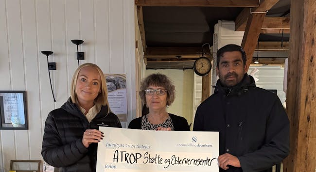 Margrethe Jakobsen (t.v) og Stian Johnsen (t.h) fra Spareskillingsbanken overrekker sjekk fra Juledryss til Atrop støtte- og ettervernsenter.