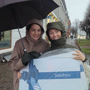 Heidi Aanundsen (t.v) og Ingrid Særsland fra Spareskillingsbanken er på vei ut i "desemberstormen" for å levere ut sjekker fra Juledryss 2025.