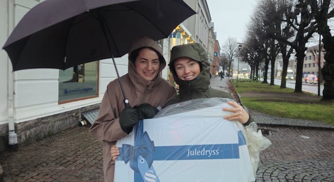 Heidi Aanundsen (t.v) og Ingrid Særsland fra Spareskillingsbanken er på vei ut i "desemberstormen" for å levere ut sjekker fra Juledryss 2025.